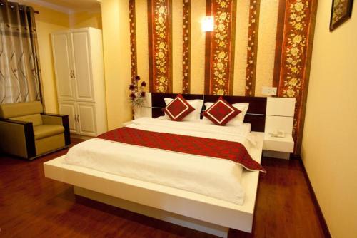 a bedroom with a large bed and a chair at Linh Phuong 2 Hotel in Can Tho