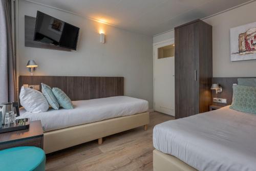 En eller flere senge i et værelse på Hotel Damsquare