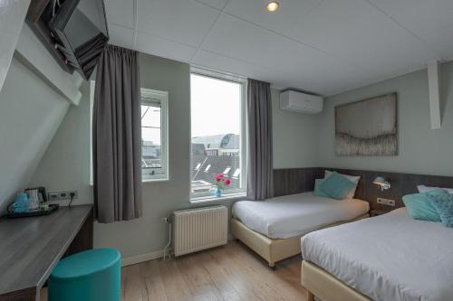 En eller flere senge i et værelse på Hotel Damsquare