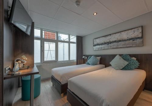 En eller flere senge i et værelse på Hotel Damsquare