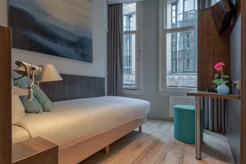 En eller flere senge i et værelse på Hotel Damsquare