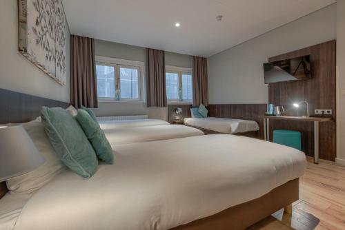 En eller flere senge i et værelse på Hotel Damsquare