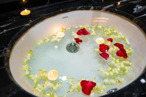 a sink with flowers and candles in it at Le Chen Miiya Hotel in Sihanoukville