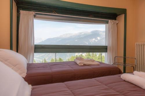 een slaapkamer met een raam met uitzicht op een berg bij Hotel la Torre in Sauze dʼOulx