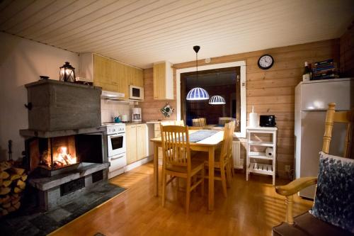 eine Küche mit einem Tisch und eine Küche mit einem Kamin in der Unterkunft Lake Kesänki Cottage in Äkäslompolo