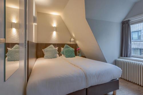 En eller flere senge i et værelse på Hotel Damsquare