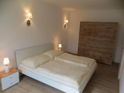 a bed in a room with two lights on the wall at City Apartment Amadeus in Salzburg