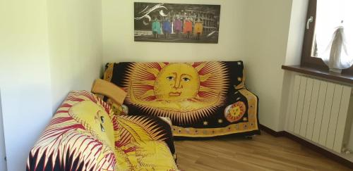 a living room with a couch and a chair with a picture at Casa Ramus Valle Camonica a 30 km dal Passo Tonale in Edolo