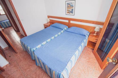 ein kleines Schlafzimmer mit einem Bett mit blauer Bettwäsche in der Unterkunft Montecarlo Apartamento39 in Puerto Rico de Gran Canaria
