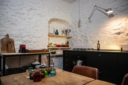 eine Küche mit einem Holztisch und einer weißen Wand in der Unterkunft Vintage House in centro storico Basilicata Puglia in Irsina