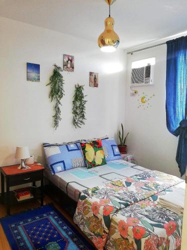 a bedroom with a bed and a table with a lamp at The Escape Pad 1 by Sharon May in Manila