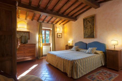 um quarto com uma cama, uma cómoda e uma televisão em Relais Poggio Borgoni em San Casciano in Val di Pesa