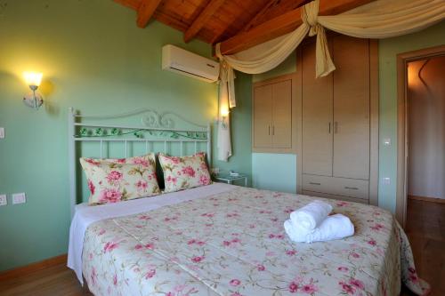 a bedroom with a large bed with pink flowers at Villa Theodora View Apartments Zeys in Agios Georgios Pagon