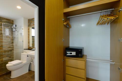 La salle de bains est pourvue de toilettes et d'une télévision sur un comptoir. dans l'établissement SiRi Ratchada Bangkok, à Bangkok