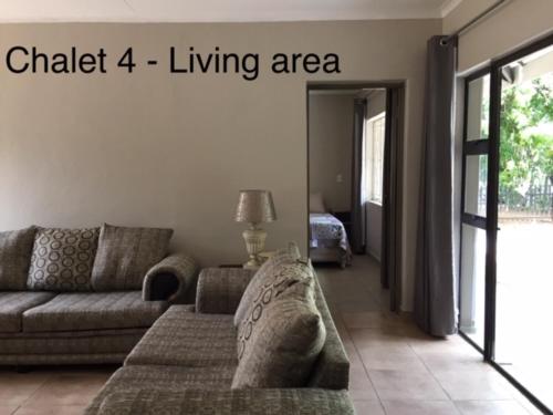 a living room with a couch and a living area at Impala Chalets in Phalaborwa