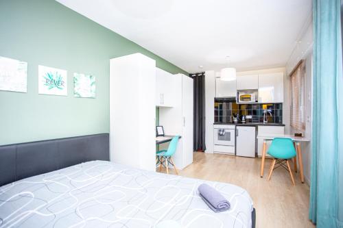 a bedroom with a large bed and a kitchen at SMILE APPARTS - Appartements - Au coeur de Lorient - Au calme - Tout Confort in Lorient
