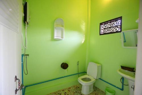 uma casa de banho verde com um WC e um lavatório em PP Red Tuna Hut em Phi Phi Don