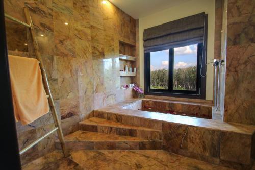 a bathroom with a tub and stairs with a window at Resona Pool Villa by Aonanta Group in Ao Nam Mao