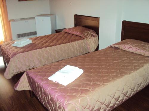 two beds in a hotel room with two beds at Hotel Terelidis House in Varikón