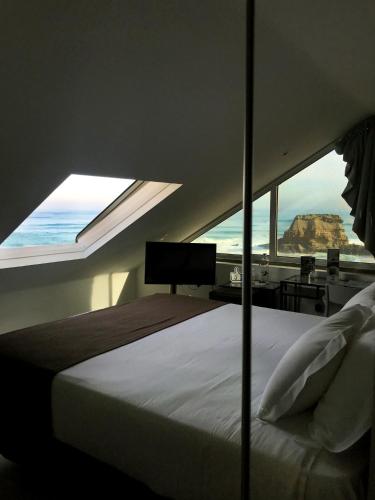 a bedroom with a bed with a view of the ocean at Promar - Eco Beach & Spa Hotel in Maceira
