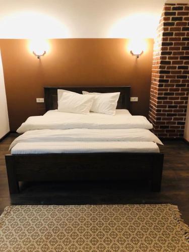 a bedroom with a large bed with two pillows at Popasul din Pietrar in Preluca Veche