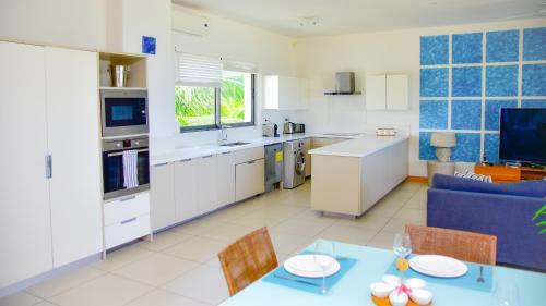 Una cocina y una sala de estar con una mesa y un sofá. en Cap Ouest Beachfront Residences, en Flic en Flac