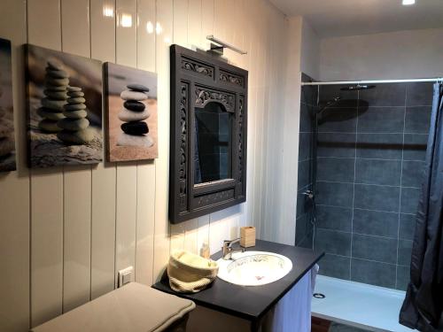 uma casa de banho com um lavatório e um chuveiro em Zoralie em Agde
