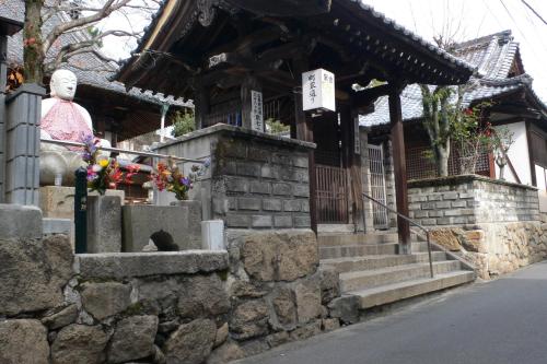 a temple with a statue in front of a building at Itsukushimahigashimonzen Kikugawa in Miyajima