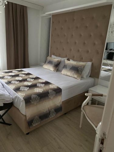 a bedroom with a large bed with a large headboard at Kispet Deluxe Hotels&Suites in Oberhausen