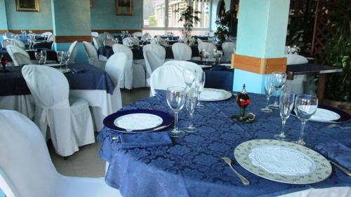 un tavolo con piatti e bicchieri da vino sopra di Hotel Carillon a Lavena Ponte Tresa