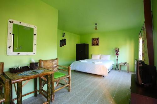 a bedroom with a bed and a table and a mirror at PP Red Tuna Hut in Phi Phi Islands