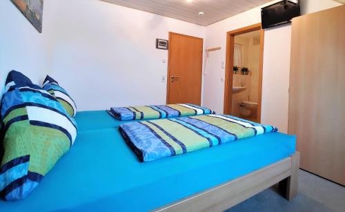 a bedroom with a blue bench with pillows on it at BodenSEE Haus am Geissbock in Meckenbeuren