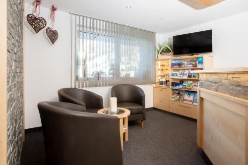 a waiting room with two chairs and a tv at OLYMPIA Privathotel Garni in Sankt Jakob in Defereggen