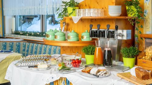 a table with food and bread on it at OLYMPIA Privathotel Garni in Sankt Jakob in Defereggen