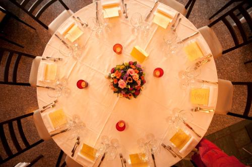 a white table with wine glasses and flowers on it at Hotel Serenella in Baveno