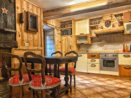 a kitchen with a table and chairs in a cabin at Le Grenier de Olga e Mario in Pré-Saint-Didier