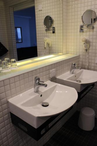 a bathroom with a white sink and a mirror at Best Western Hotel Corallen in Oskarshamn