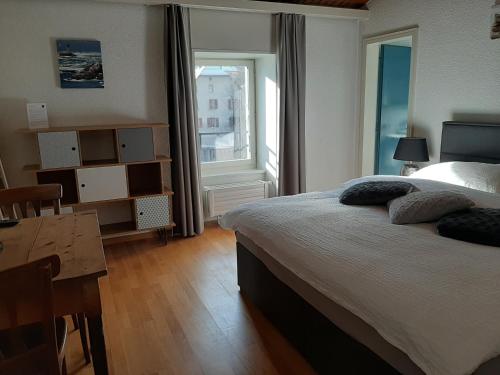 Schlafzimmer mit einem Bett, einem Tisch und einem Fenster in der Unterkunft Hotel Restaurant Le Giétroz in Le Châble