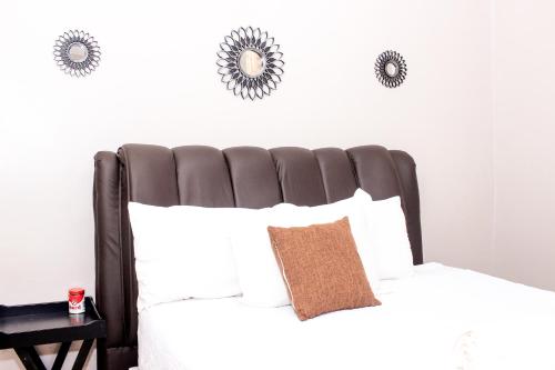 a bedroom with a black and white bed with white pillows at Villa Prince in Harare