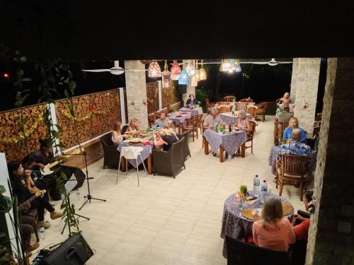 a group of people sitting at tables on a stage at Sea Breeze Candidasa in Candidasa