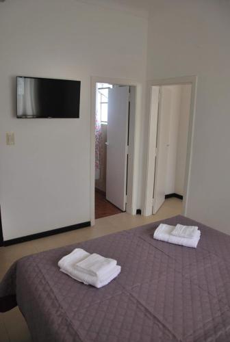 a bedroom with a bed with two towels on it at Sur Hotel in Necochea