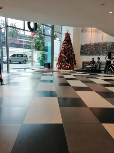 a christmas tree in a building with people sitting around it at ACQUA Private Residences 1BR Condo in the heart of downtown Makati & Mandaluyong in Manila