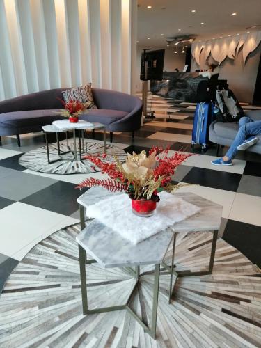 a lobby with couches and tables with flowers on them at ACQUA Private Residences 1BR Condo in the heart of downtown Makati & Mandaluyong in Manila