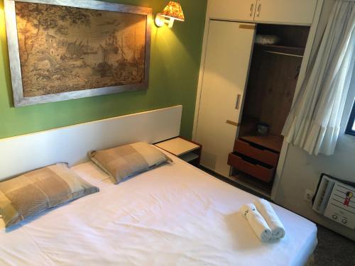 1 dormitorio con 1 cama blanca y 2 almohadas en Atlântico Flat Residence, en Fortaleza