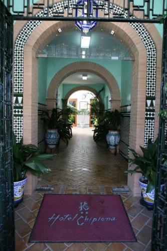 a hallway with an archway with plants in a building at Hotel Chipiona in Chipiona