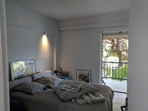 sypialnia z łóżkiem i oknem w obiekcie Green Coast w mieście Sunion