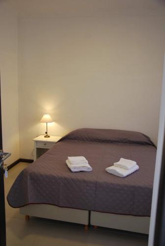 a bedroom with a bed with two towels on it at Sur Hotel in Necochea