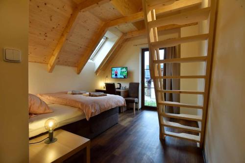 a bedroom with a loft bed and a desk at Penzion Jizerská Malina in Bedřichov