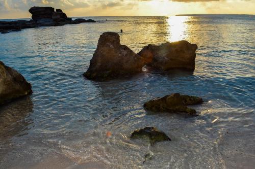 eine Gruppe Felsen im Wasser am Strand in der Unterkunft Formentera Suite 8 in Es Pujols