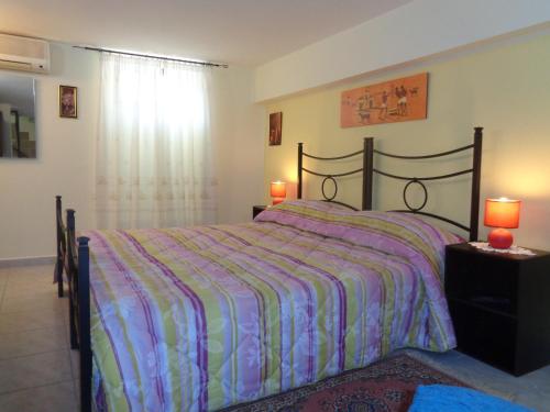 カスティリオーネ・ディ・シチーリアにあるAntico Borgoのベッドルーム1室(ベッド1台、テーブルにランプ2つ付)